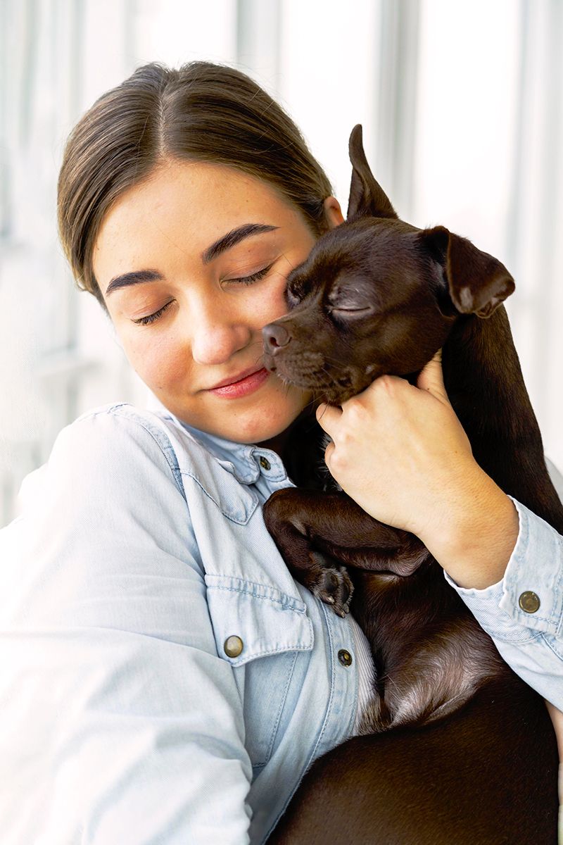 woman hugging her chihuahua dog